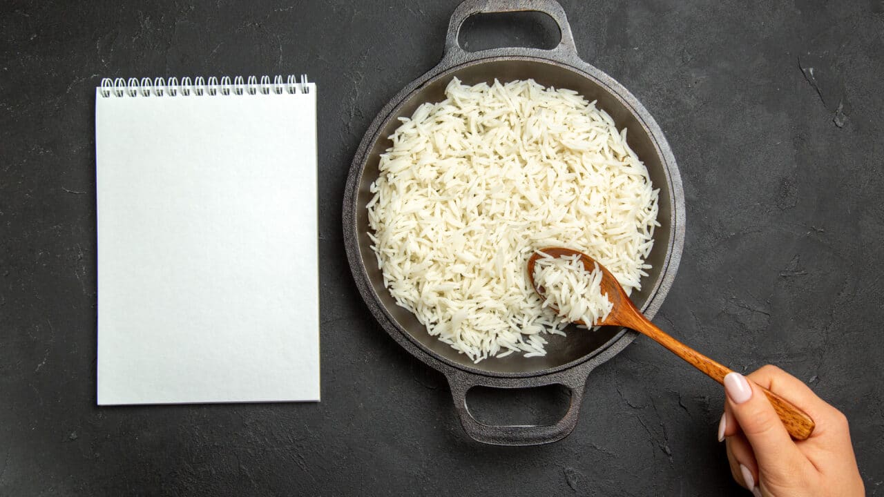 Overhead view of a large pan filled with batch-cooked rice, ready to portion for the week