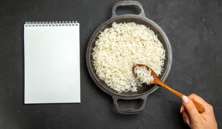 Overhead view of a large pan filled with batch-cooked rice, ready to portion for the week
