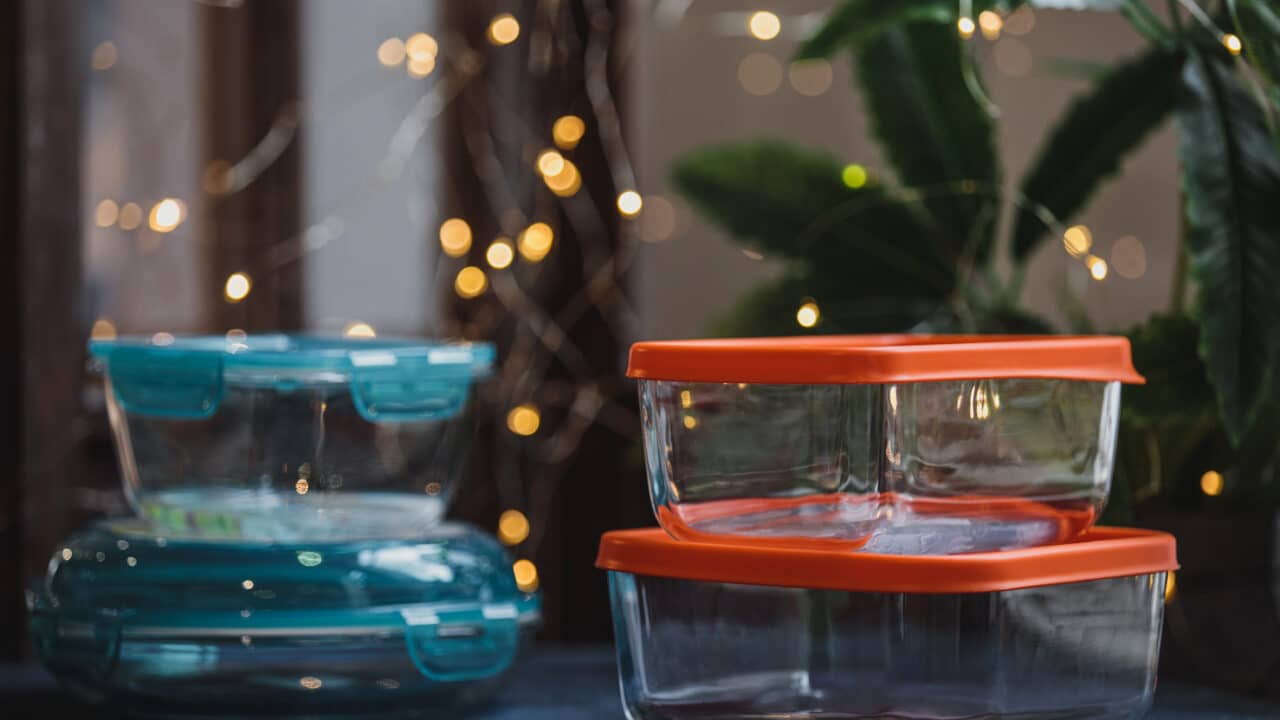 Empty glass food storage container on a dark neutral surface