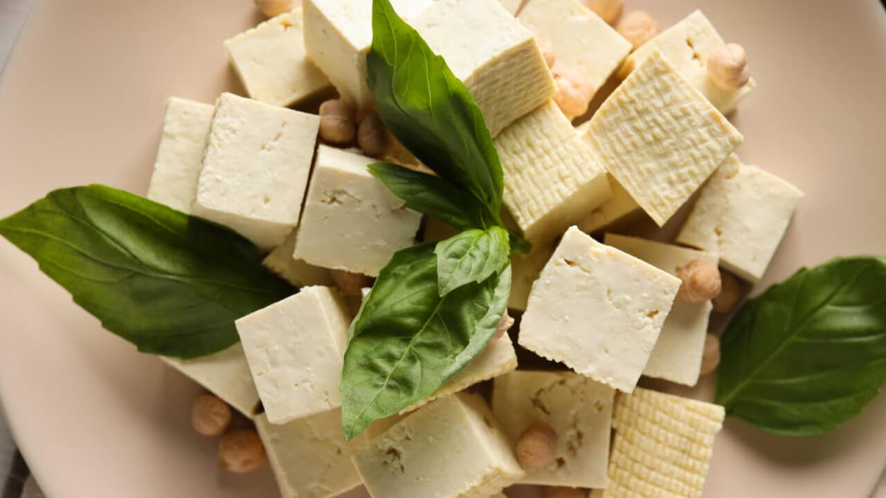 Tofu, beans, and soy in a bowl on a light background, plant-based protein ingredients for meal prep