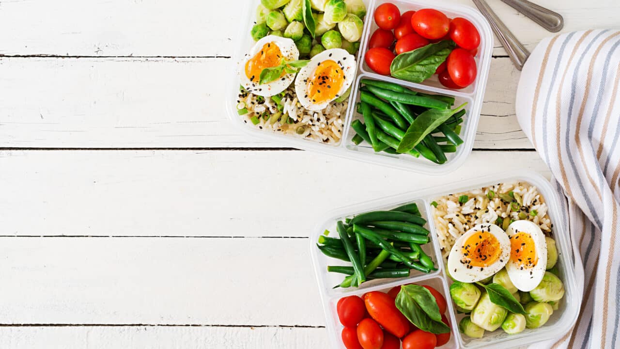 Meal prep containers with eggs and vegetables for high protein breakfast and lunch, flat lay