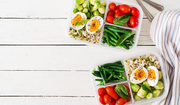 Meal prep containers with eggs and vegetables for high protein breakfast and lunch, flat lay