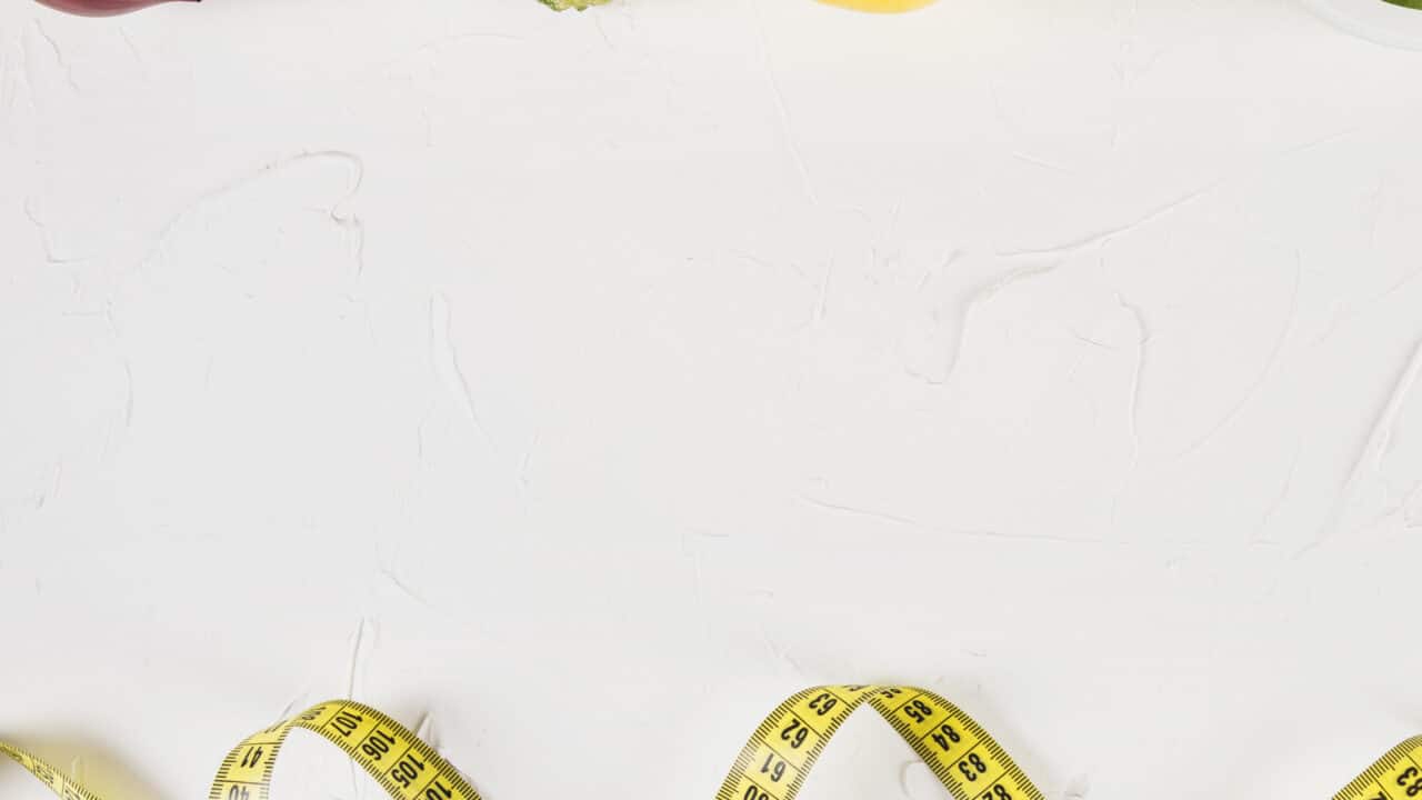 Overhead flat lay of lean protein and vegetables with a measuring tape, representing portion control for low-calorie high-protein meal prep