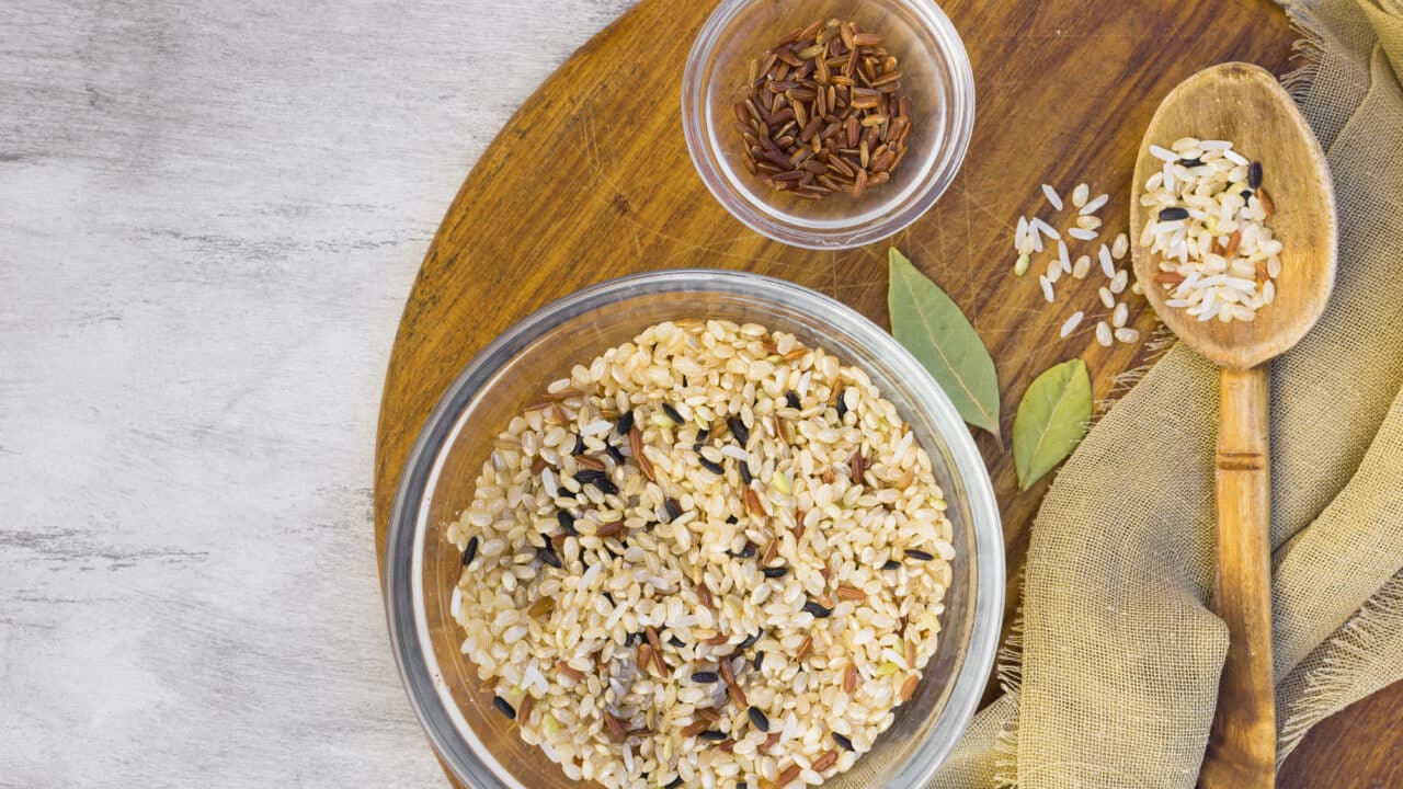 Bowls of dry rice and grains on a light table