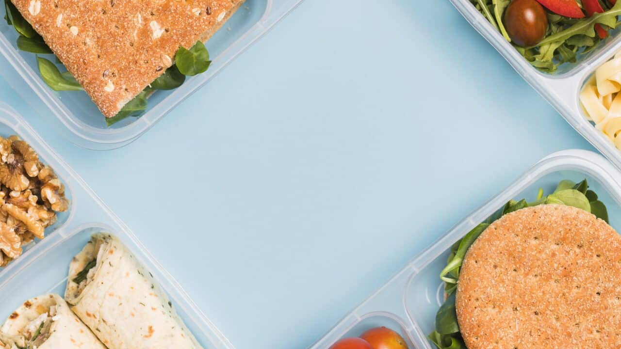 Family meal planning: multiple lunchboxes packed with different meals, viewed from above