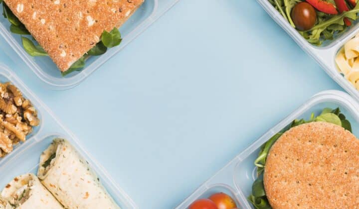 Family meal planning: multiple lunchboxes packed with different meals, viewed from above