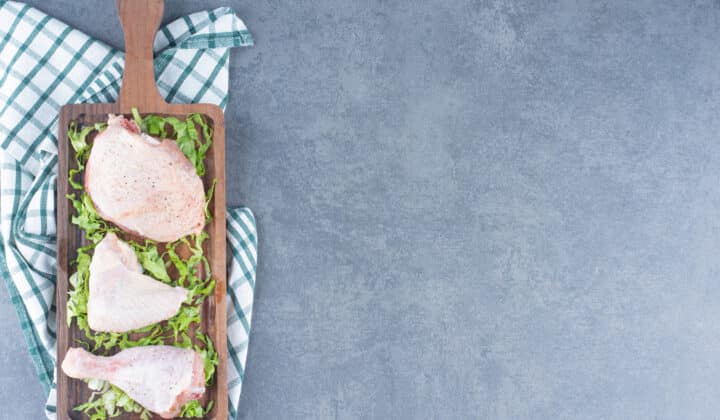 Raw chicken pieces on a wooden board