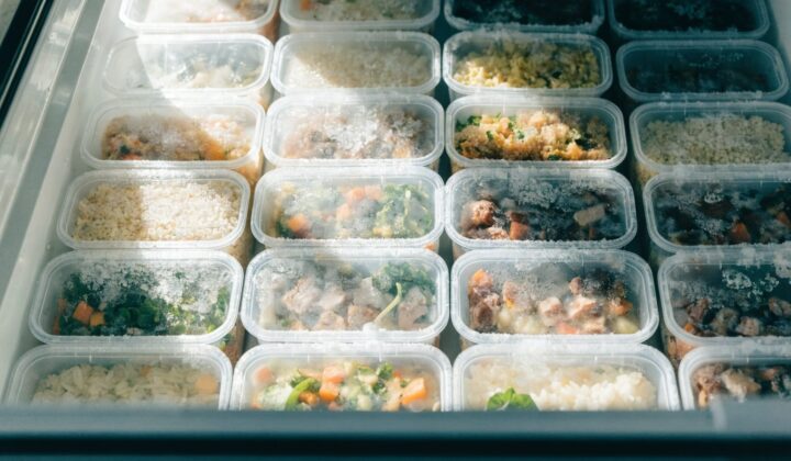 Meal prep containers with pre-cooked meals organized in the freezer