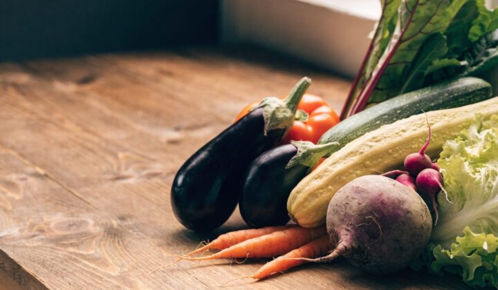 Colorful assortment of fresh vegetables on a wooden background