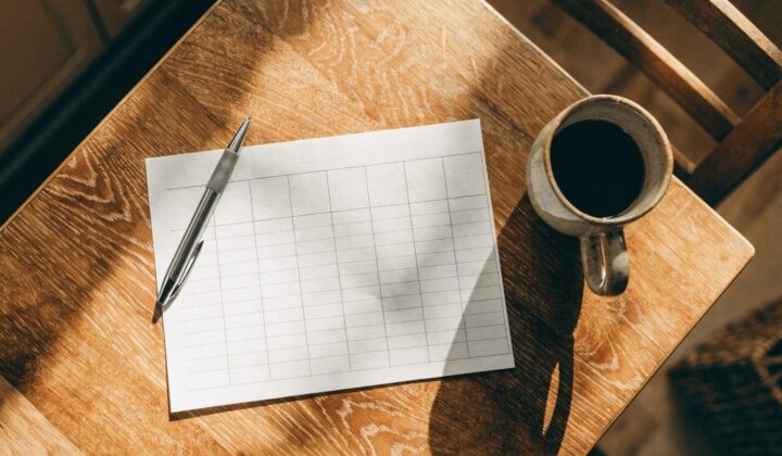 Blank weekly meal planner grid on a kitchen table, top-down view