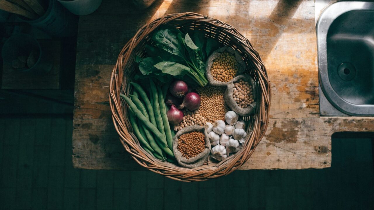 Wicker basket of fresh vegetables and dried legumes for an affordable weekly menu