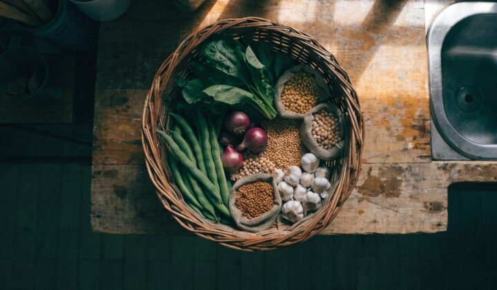 Wicker basket of fresh vegetables and dried legumes for an affordable weekly menu