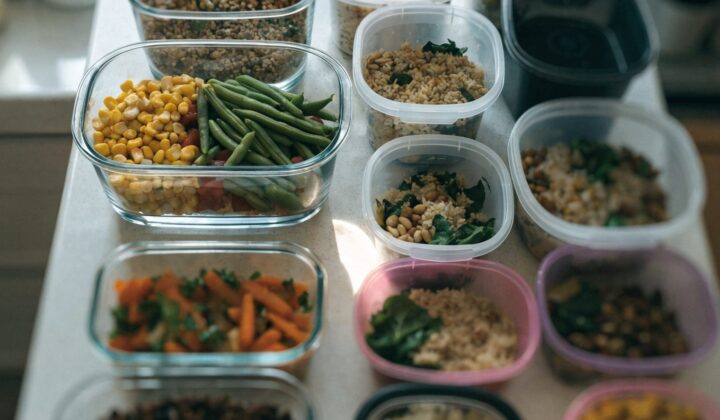 Glass and plastic meal-prep containers with prepared food, top-down view