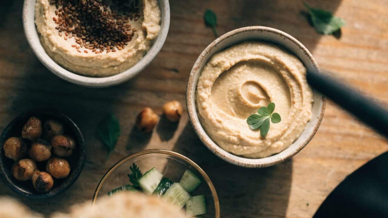 Overhead flat lay of bowls with hummus and roasted chickpeas for vegetarian and vegan batch cooking