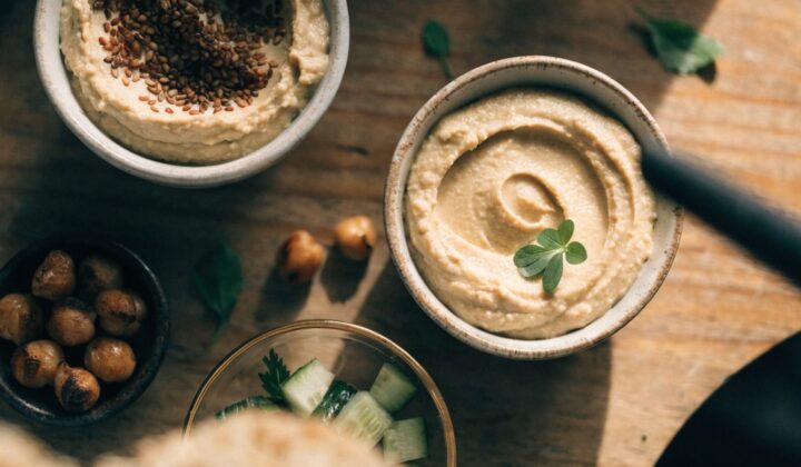 Overhead flat lay of bowls with hummus and roasted chickpeas for vegetarian and vegan batch cooking