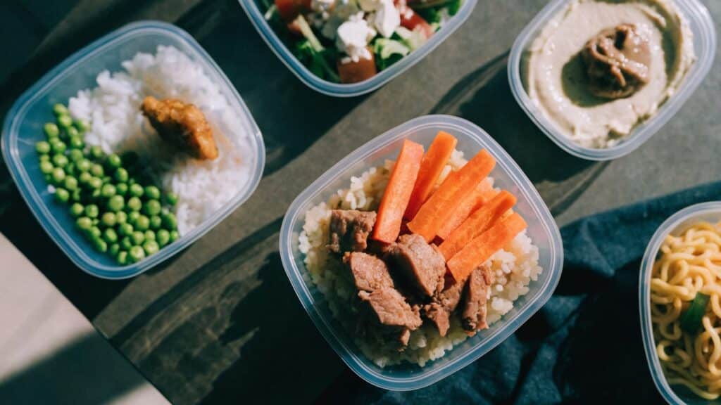 Five meal prep containers each with a different simple food combination