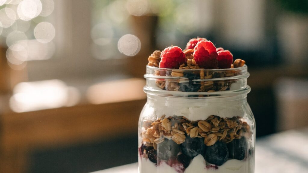 Greek yogurt parfait layered in a glass jar with berries and granola